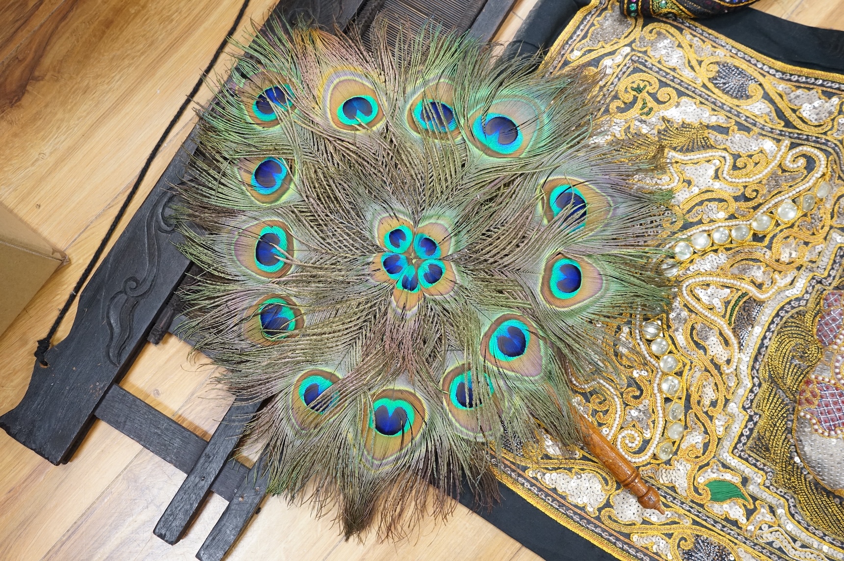 A quantity of mostly 20th century Middle Eastern and Indian woven and printed textiles and a peacock feather fan (2 boxes).